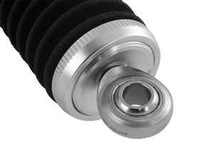 Close-up of an aluminum shock end cap with a spherical rod end bearing, fitted with a black knit shock cover